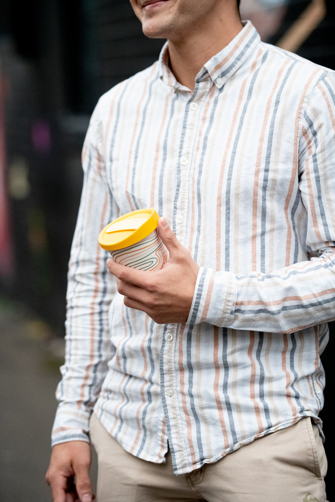 Man holding cup with reusable lid